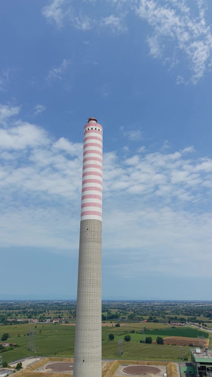 Vista aerea con drone della grande ciminiera industriale della centrale elettrica di Tavazzano-Montanaso in Lombardia, Italia, che evidenzia l'infrastruttura energetica su larga scala.