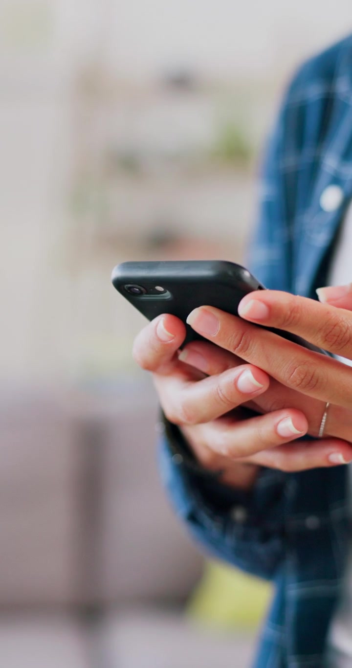 Primo piano di persona che usa lo smartphone in un ambiente casual