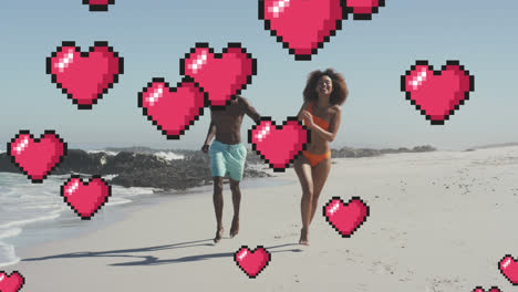 animación de corazones flotando sobre una feliz pareja afroamericana corriendo en la playa