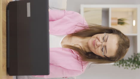 el video vertical de la mujer con dólares en la mano en la computadora portátil se alegra.