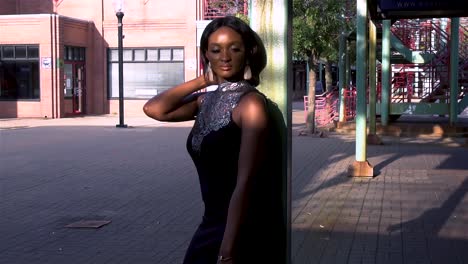 African-woman-wearing-a-black-dress-and-holding-a-red-hand-back-is-standing-in-China-Town-Square