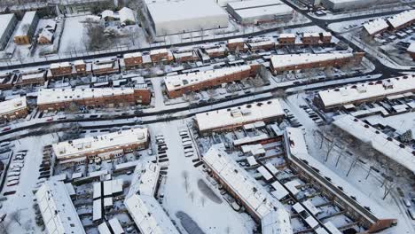 aerial of beautiful snow covered suburban neighborhood with cars driving over clean road