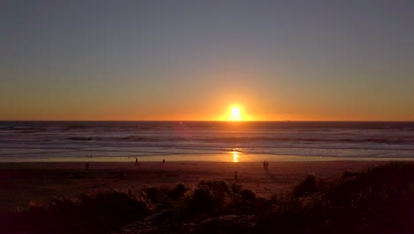 Slow-motion,-fixed-position-handheld-shot-of-sunset-over-a-very-windy-Ocean-Beach,-San-Francisco,-California