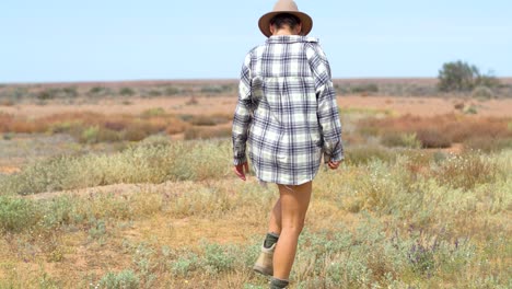una niña camina y observa un desierto en flor, después de las inundaciones del interior
