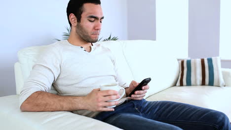 Man-drinking-a-coffee-while-using-his-notebook