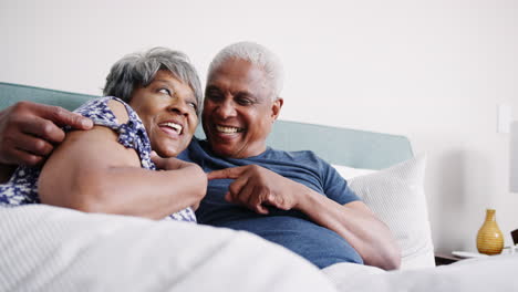 Amorosa-Pareja-De-Ancianos-Abrazándose-En-La-Cama-Por-La-Mañana