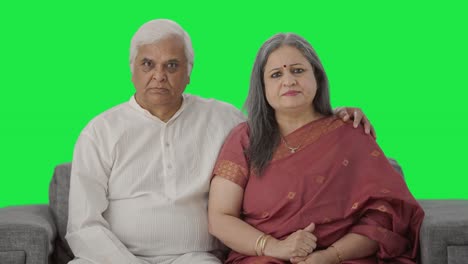 una pareja de ancianos indios enojados mirando la pantalla verde de la cámara
