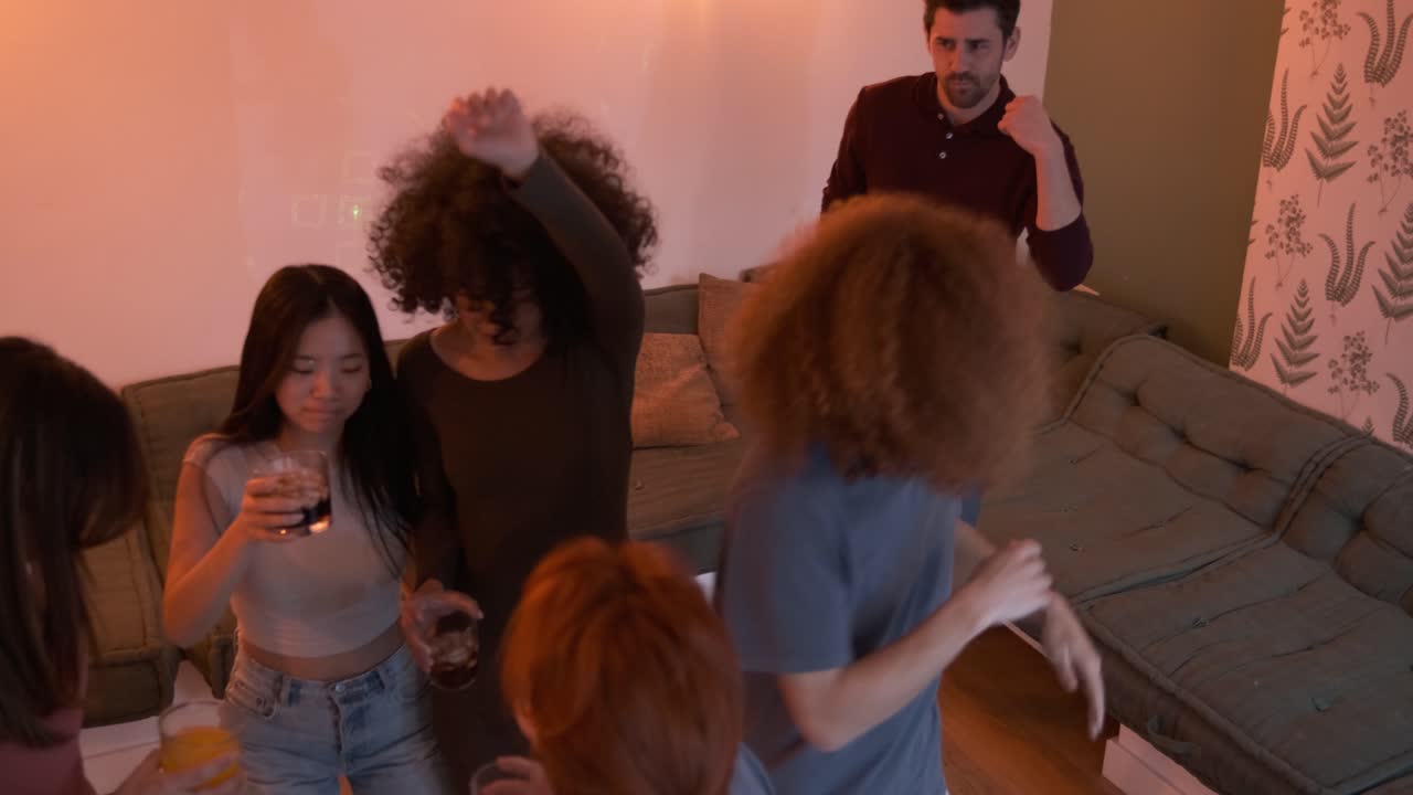 Excited friends grooving to music while enjoying weekend party in living room at home