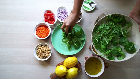 Agregando-Hojas-De-Espinaca-Al-Plato-Vista-Aérea-De-Todos-Los-Ingredientes-En-La-Mesa