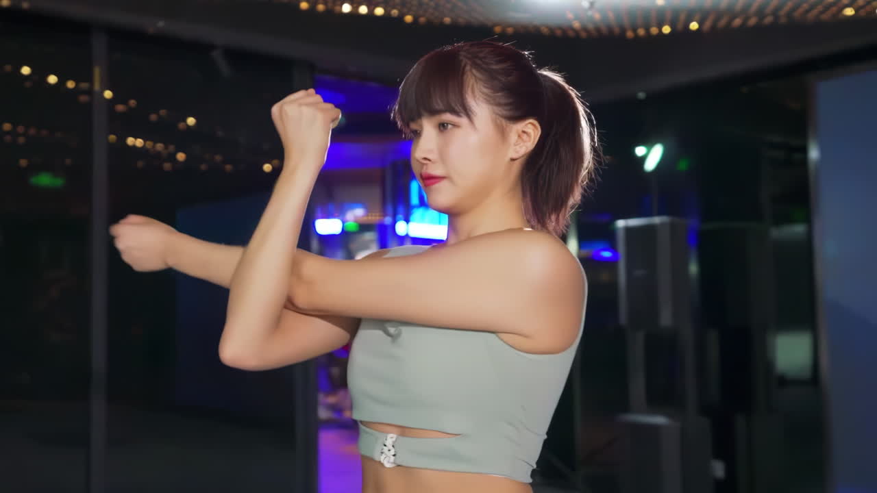 체육관에서 스포츠 운동을 하기 전에 몸을 따뜻하게 하기 위해 손을 펴고 있는 아름다운 매력적인 여성