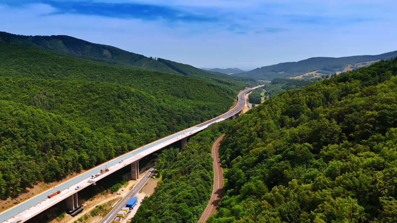 Winding road in green mountains. A highway snakes through verdant mountains under a clear blue sky, showcasing nature's beauty and human engineering