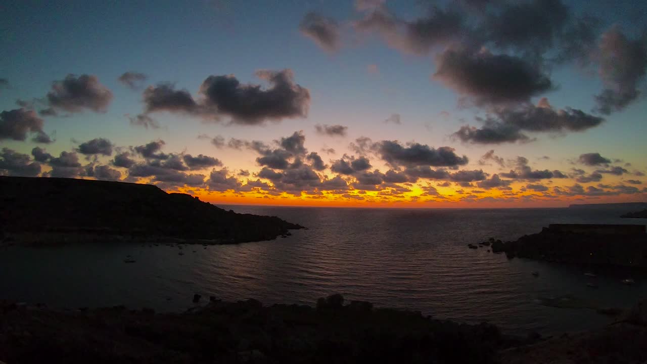 Impresionante movimiento de nubes sobre el mar, horizonte dorado justo después del atardecer en la costa de la isla mediterránea de Malta