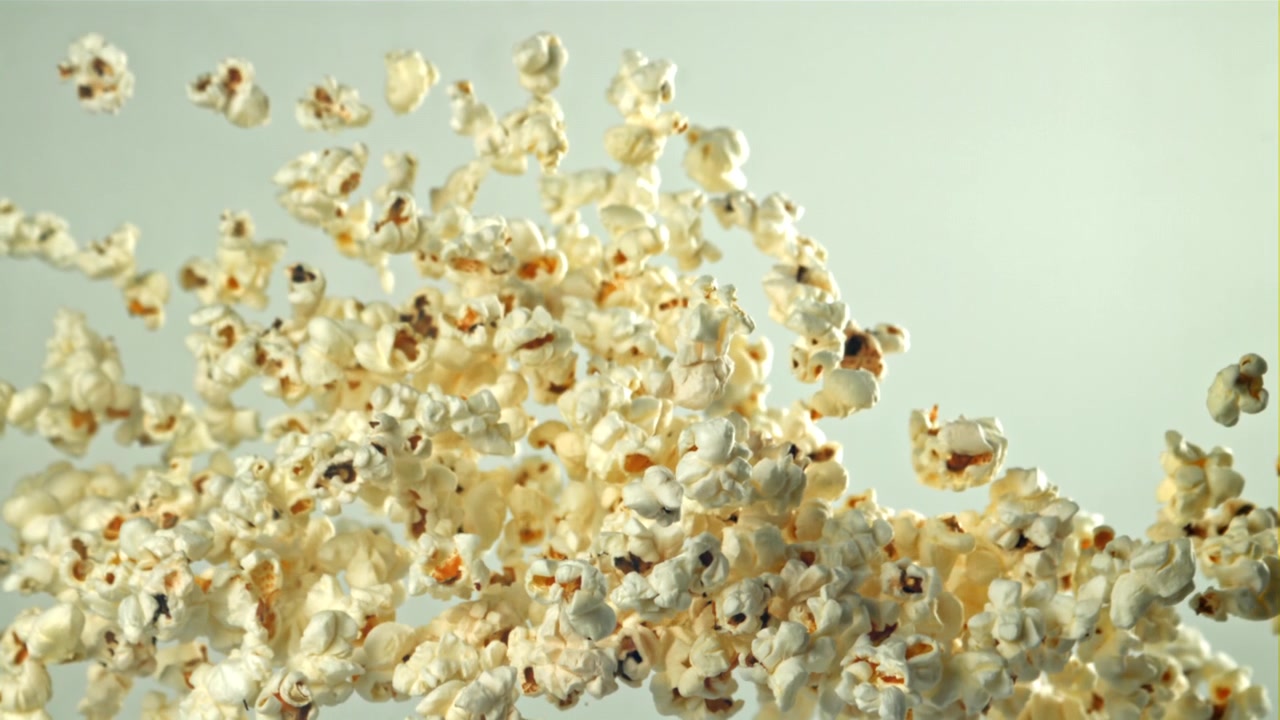 Popcorn Flying Up in Slow Motion on a Light Background