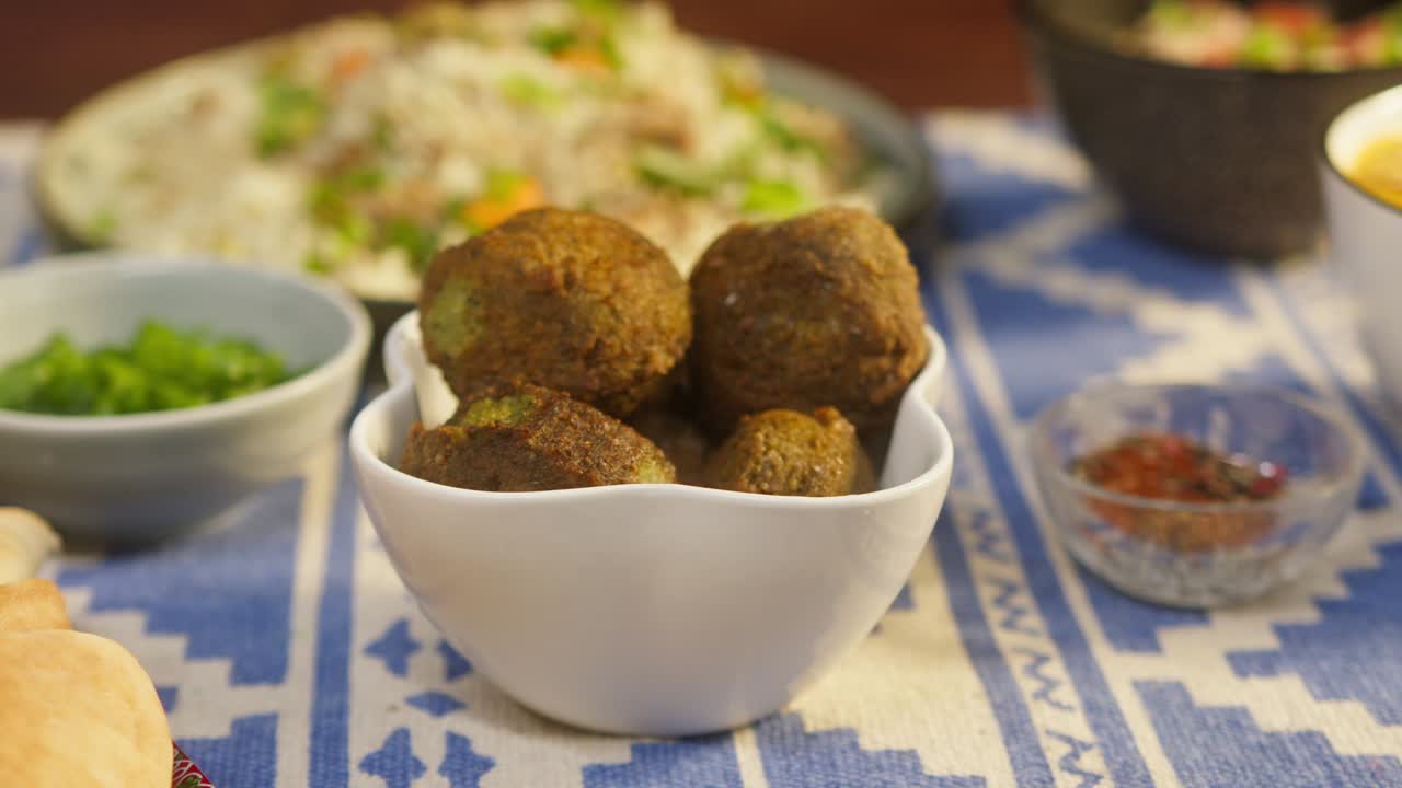 comer falafel de cerca. cocina árabe. cultura tradicional de oriente medio. delicioso arroz con carne en el fondo. tomando a mano bolas de garbanzos fritos