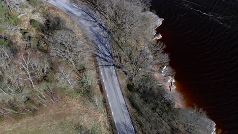 aerial - road and lakeshore in bohuslan, sweden, wide spinning shot