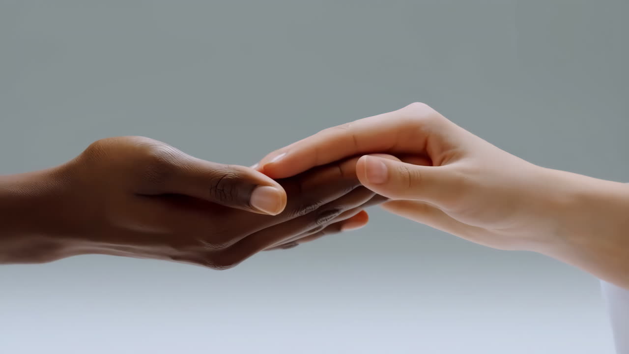 Two Diverse Hands Gently Interlocking Fingers