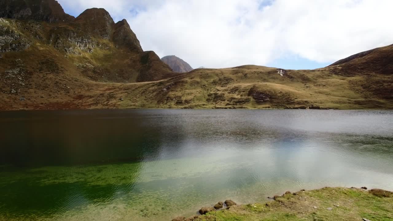vista aérea del lago azul profundo que refleja la montaña con una enorme montaña detrás durante el otoño en suiza