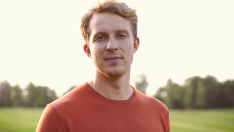 portrait of a man smiling and looking at camera in the park 1