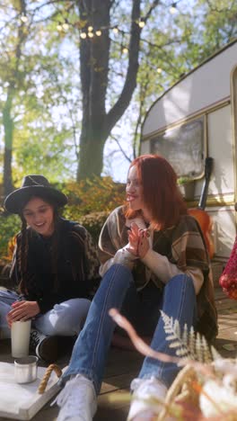 friends enjoying an autumn day by a camper