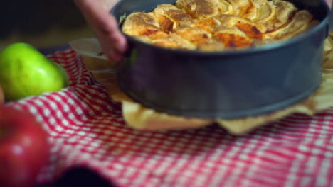 Frisch-Gebackener-Apfelkuchen.-Nahaufnahme.-Hände-Legen-Bratapfelkuchen-Auf-Den-Tisch