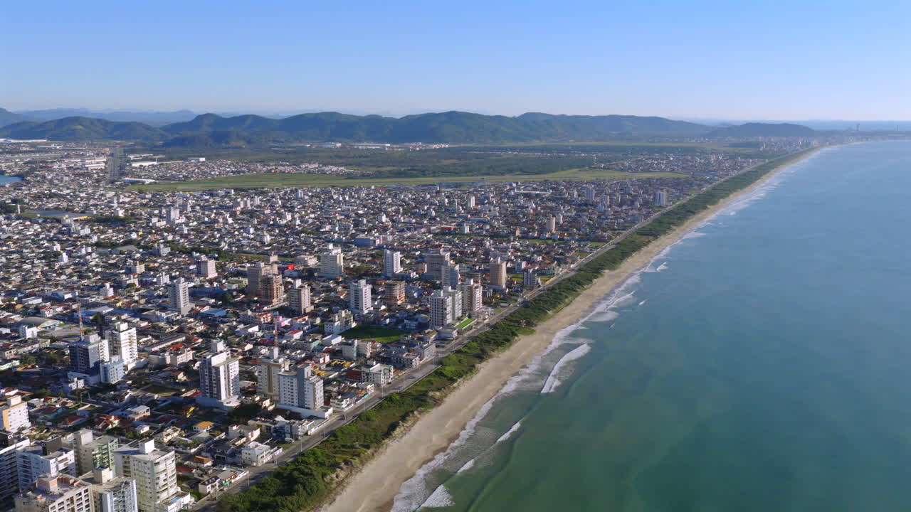 Aerial drone view of Navegantes, Santa Catarina, Brazil, showing the coastal city with its beach and the international airport in the background