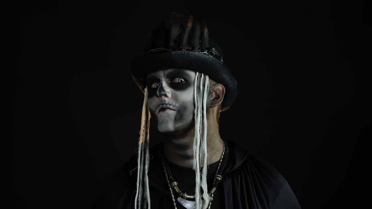 Mann mit gruseligem Totenkopf-Make-up blickt ständig in die Kamera und schüttelt den Kopf. Halloween-Kostüm.