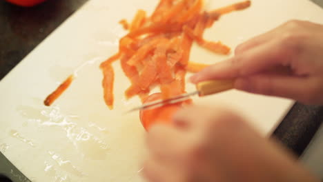 female hands peeling a carrot in the kitchen in slow motion