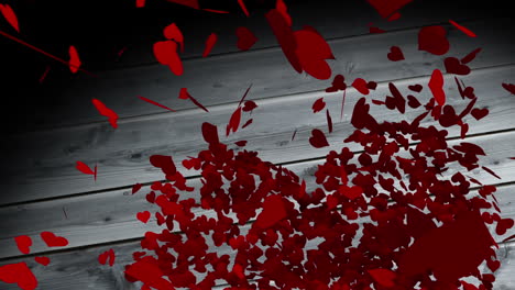 Red-hearts-falling-on-wooden-surface