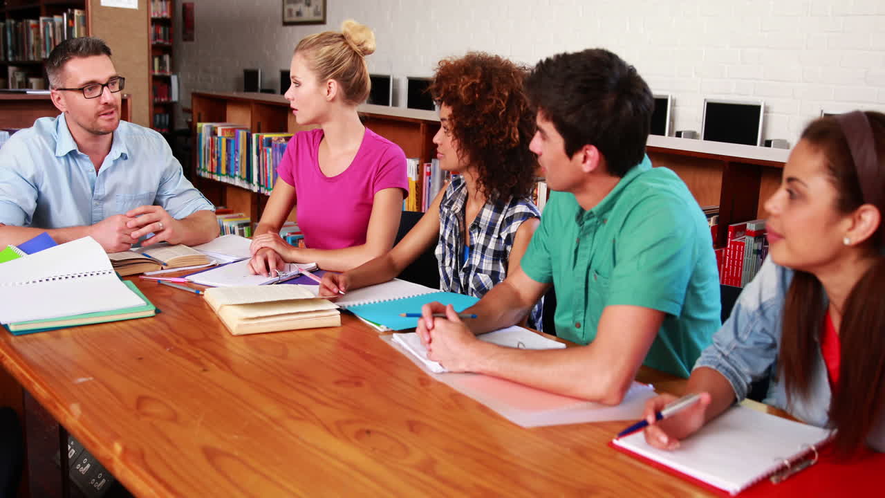 estudiantes jóvenes estudiando juntos en la biblioteca con su maestro