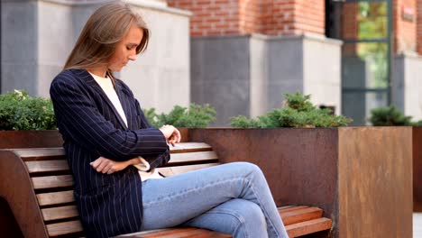 serious business woman sitting outside office and looking around