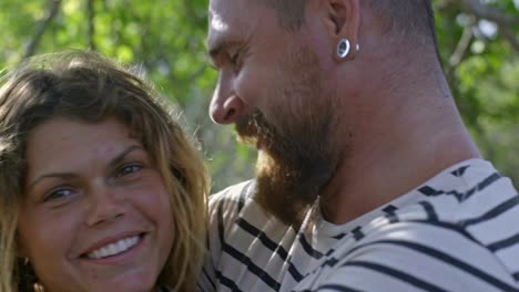 una pareja enamorada abrazándose y sonriendo en un día soleado.