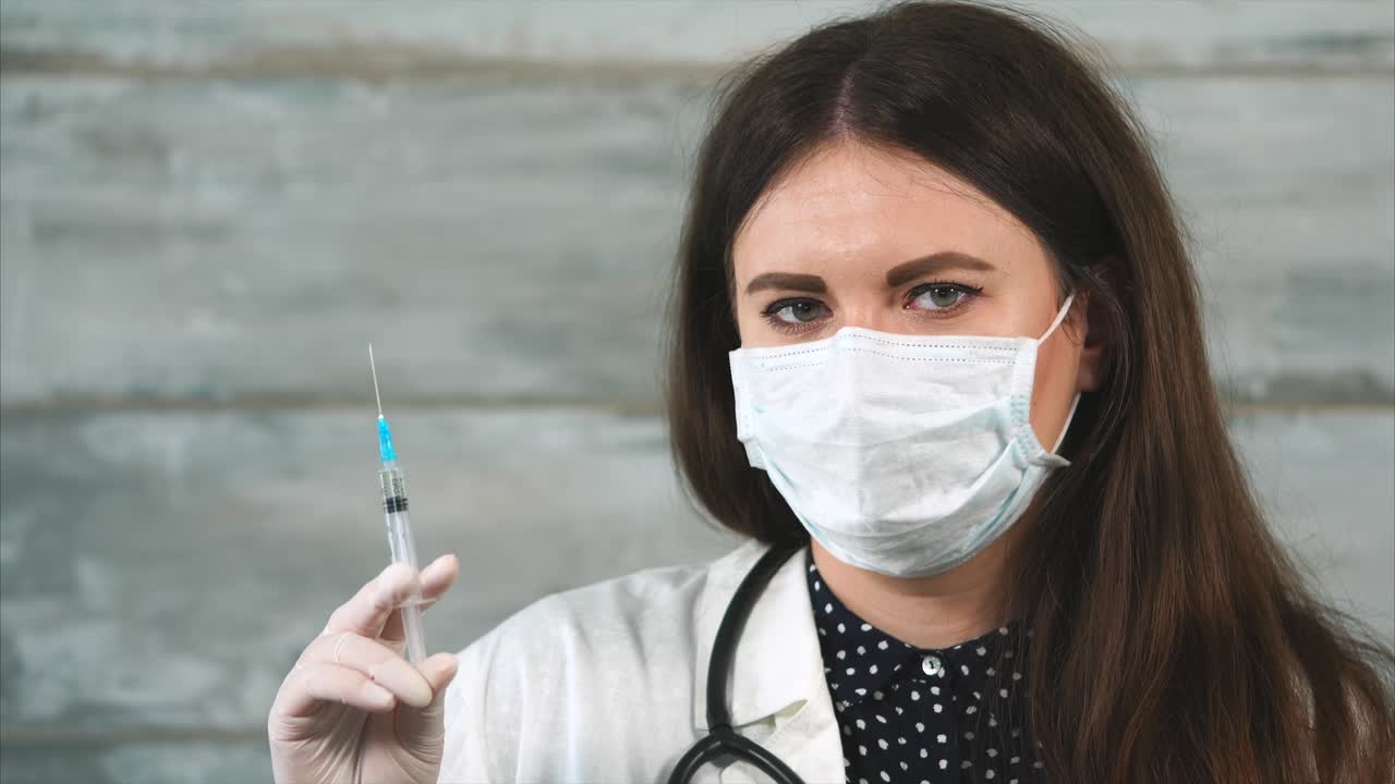 médico con jeringa y máscara