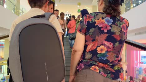 people standing on the mall escalator going up