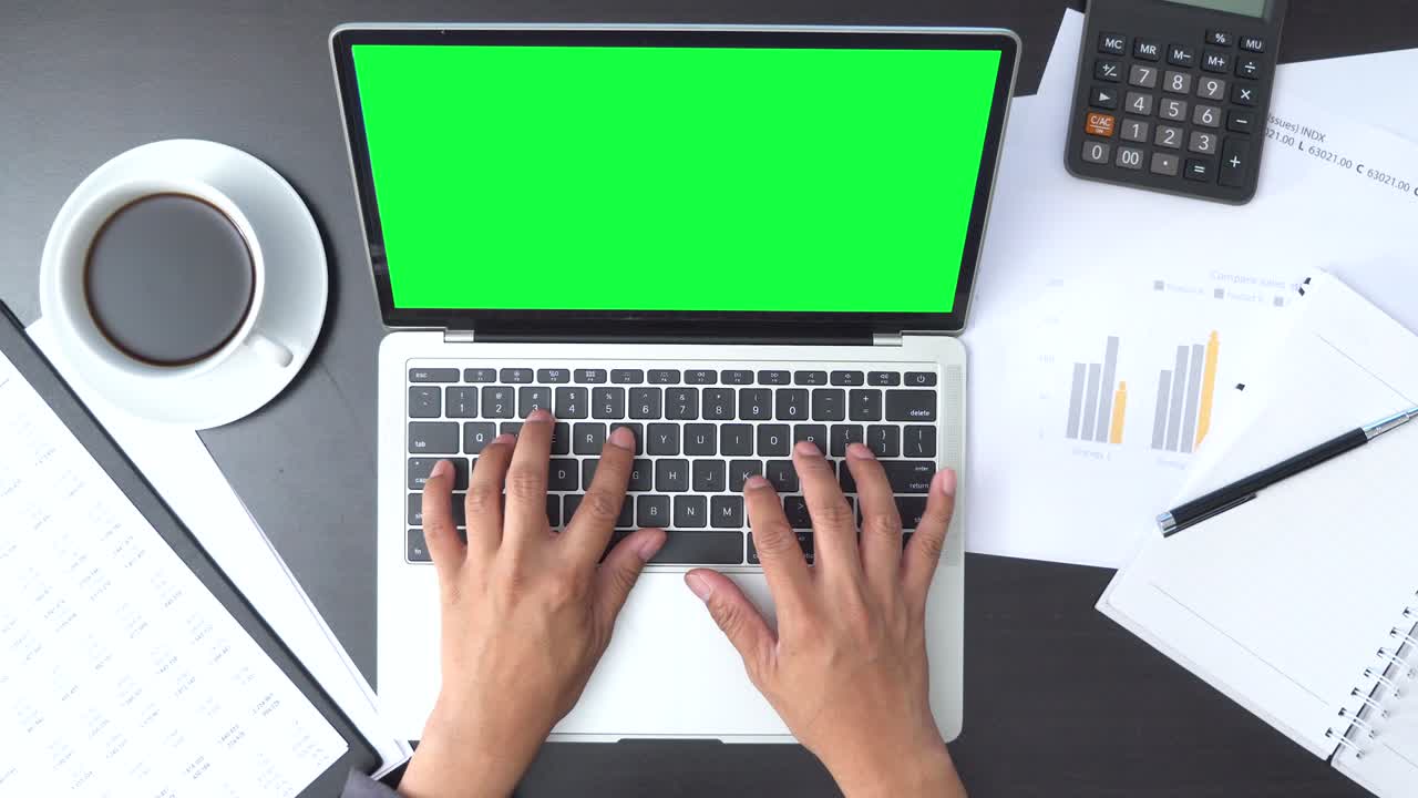 Top View of Businessman working with Green Screen laptop and documents with graphs and diagrams