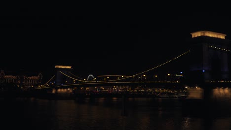 the beautiful lighted chain bridge of budapest during the night - wide pan