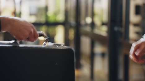 suited man hands over a black business suitcase, sealing the deal with a firm handshake. professionalism, high-stakes negotiations, corporate agreements, confidential exchanges. business, finance.