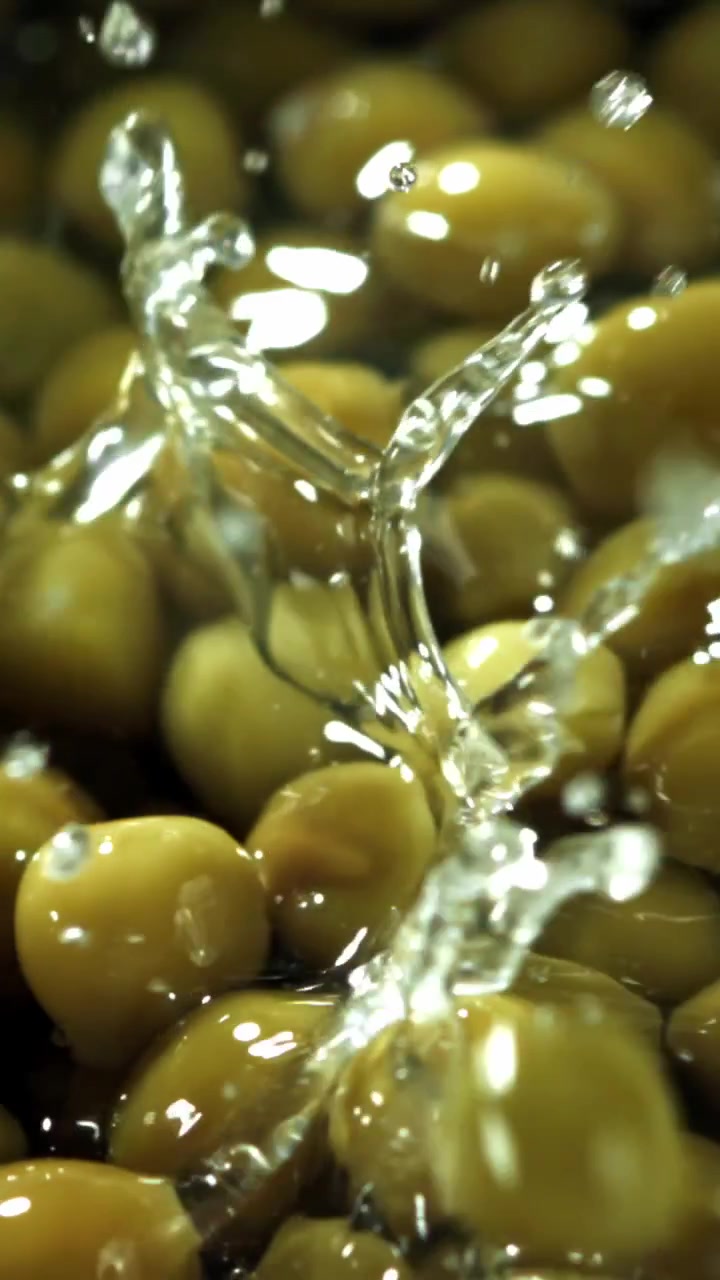 Rallentatore di piselli verdi che cadono nell'acqua