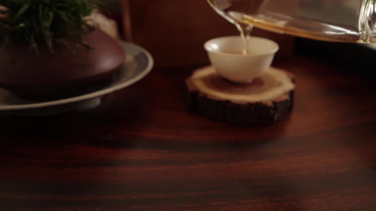 pouring tea from tea jug to tea cup