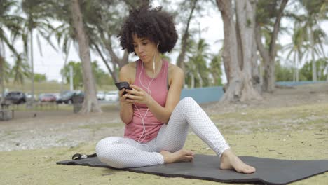 mujer joven escalofriante usando el teléfono en la alfombra