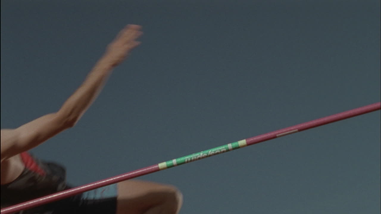 한 남자가 장대 위로 높이뛰기를 한다