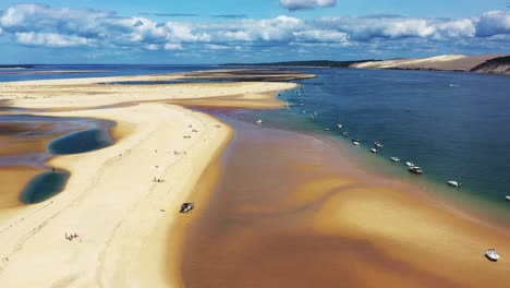 banc d'arguin in arcachon bay france with boats stationed in a row along the sandbank, aerial flyover view