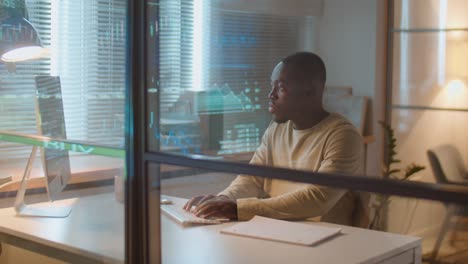 african american stock market trader working in office at night
