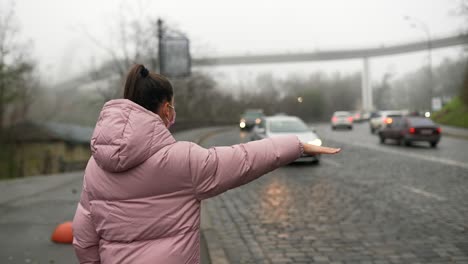 woman waiting for a ride in the city on a foggy day