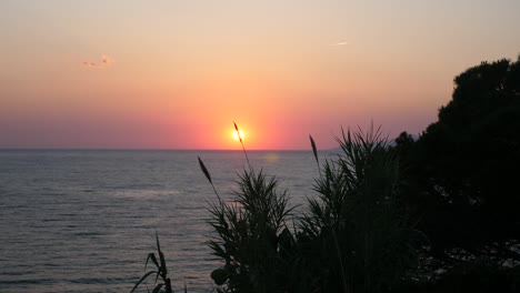 a wide shot of a sunset in palinuro, italy during the summertime