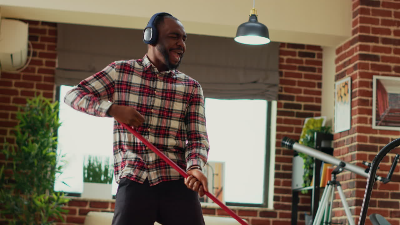 African american man dancing and using mop to wash floors