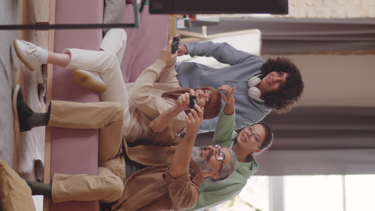 padres alegres jugando a un juego de consola con la ayuda de niños adolescentes