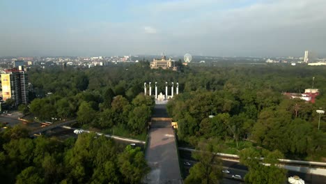 Dolly-in-over-the-Altar-a-la-Patria-with-the-Chapultepec-Castle-with-the-Mexican-flag-flying-above-it,-CDMX-on-a-very-polluted-day