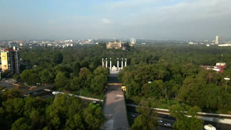 dolly en sobre el altar a la patria con el castillo de chapultepec con la bandera mexicana ondeando por encima de él, cdmx en un día muy contaminado