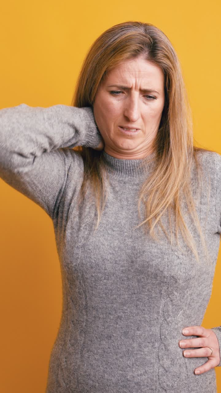 Donna che soffre di mal di testa e dolore al collo su sfondo giallo