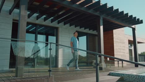 happy man stretching on luxury house porch. leisure morning concept